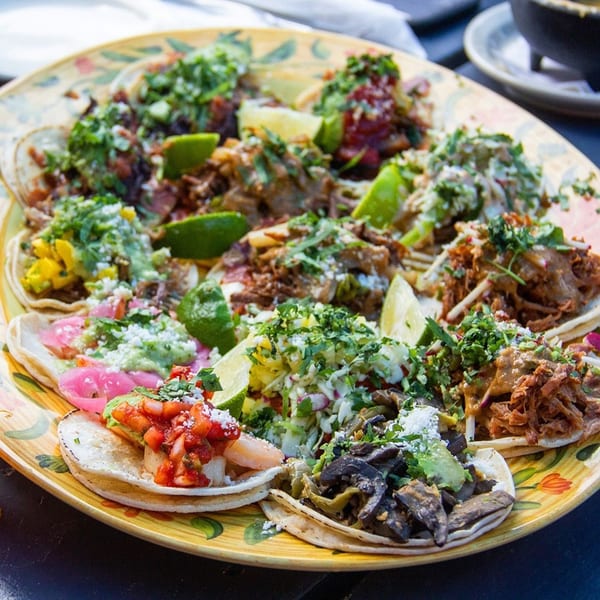 A vibrant platter of Uno Mas Taqueria y Cantina's diverse tacos, garnished with fresh lime.
